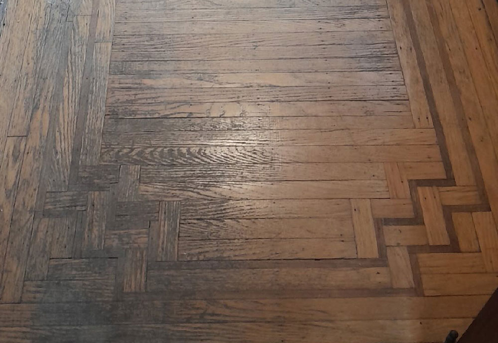 Worn hardwood floor before refinishing